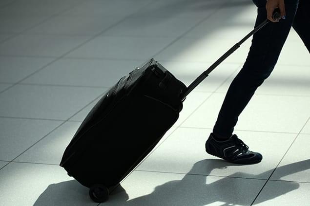 Image of a person dragging a suitcase